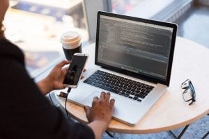 Person looking at mobile and laptop